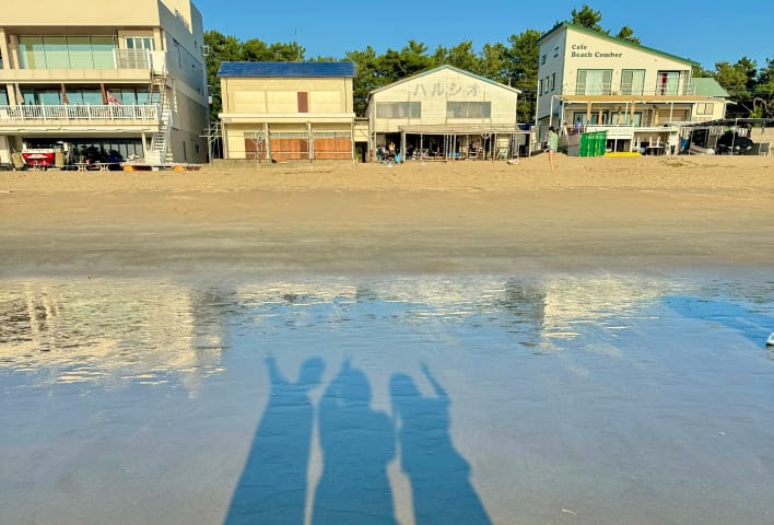 浜辺で影の写真を撮る3人